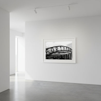 Monochrome seascape photo capturing the serene beauty of the Forty Foot bathing spot in Dublin, Ireland. Martello tower stands in the distance against a clear sky.