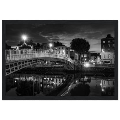 Black and white framed wall art print of Dublin's iconic Ha'penny Bridge at night. The detailed photograph captures the bridge's intricate architecture and its reflection in the River Liffey, creating a timeless and elegant piece perfect for home or office decor