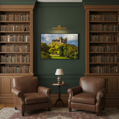 Rock of Cashel framed artwork centred on a dark green library wall with oak bookshelves, brass picture lights and leather armchairs – refined Irish heritage interior.